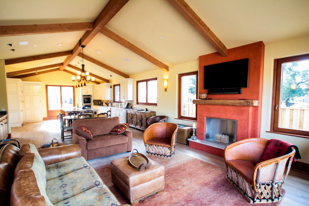 Example of a mid-sized cottage formal and open concept medium tone wood floor living room design in San Francisco with beige walls, a standard fireplace, a concrete fireplace and a wall-mounted tv