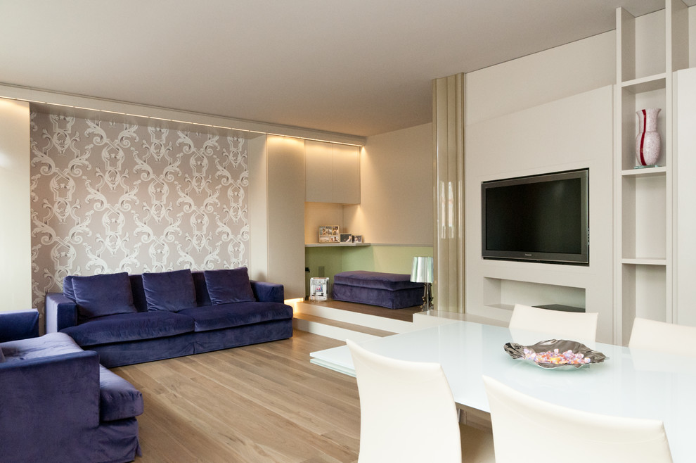 Foto de salón para visitas abierto ecléctico grande con paredes beige, suelo de madera clara y televisor colgado en la pared