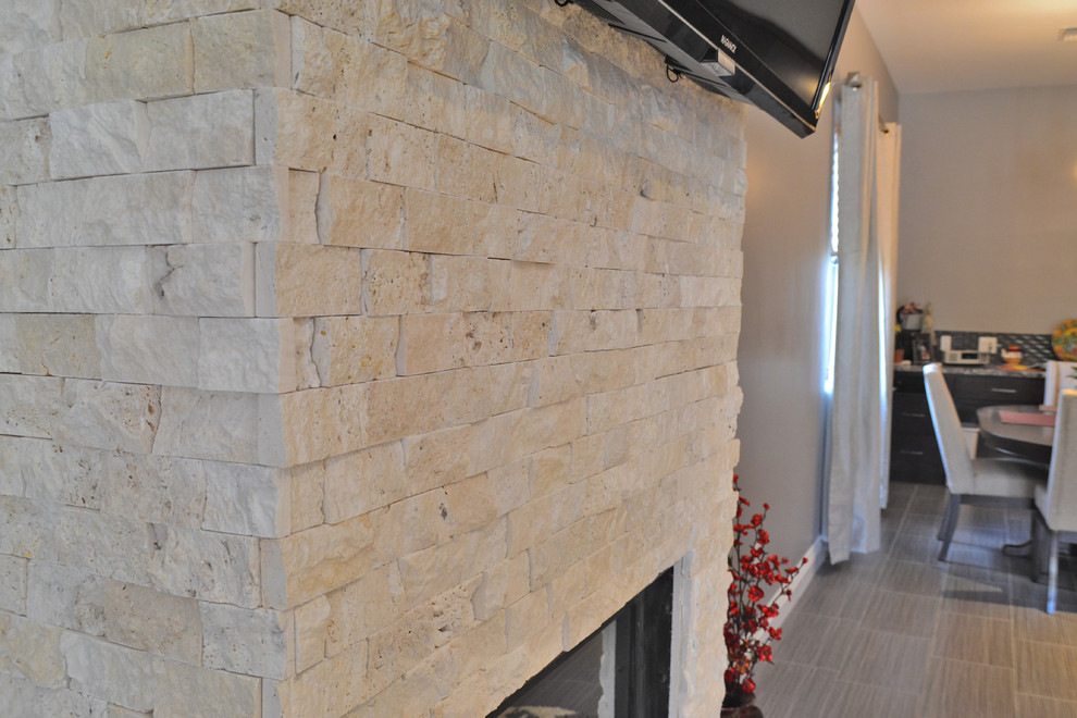 Стильный дизайн: открытая гостиная комната в стиле неоклассика (современная классика) с серыми стенами, полом из керамогранита, горизонтальным камином, фасадом камина из камня и телевизором на стене - последний тренд