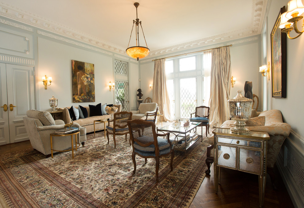 Cette image montre un grand salon traditionnel fermé avec une salle de réception, un mur bleu et un sol en bois brun.