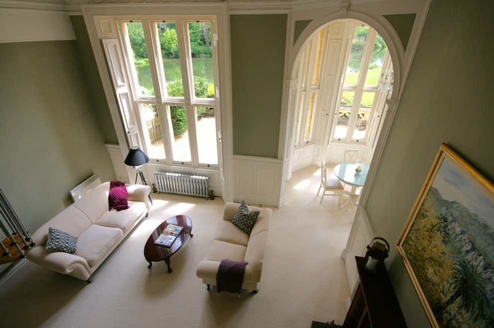 Mittelgroßes, Abgetrenntes Klassisches Wohnzimmer mit grüner Wandfarbe, Teppichboden und Kaminofen in Sonstige