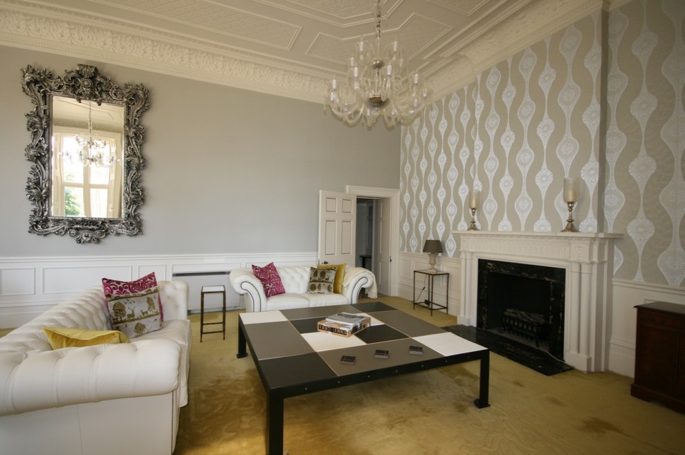 Modelo de salón para visitas cerrado clásico grande con paredes grises, moqueta, marco de chimenea de madera, televisor colgado en la pared y todas las chimeneas