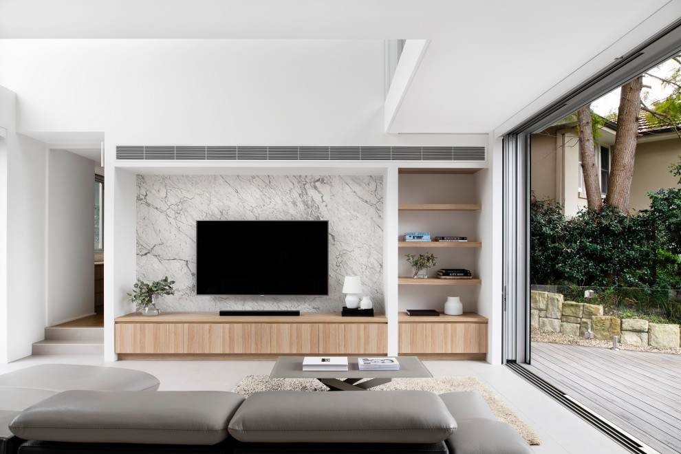 Modelo de salón abierto actual grande con paredes blancas, suelo de baldosas de cerámica, televisor colgado en la pared y suelo gris