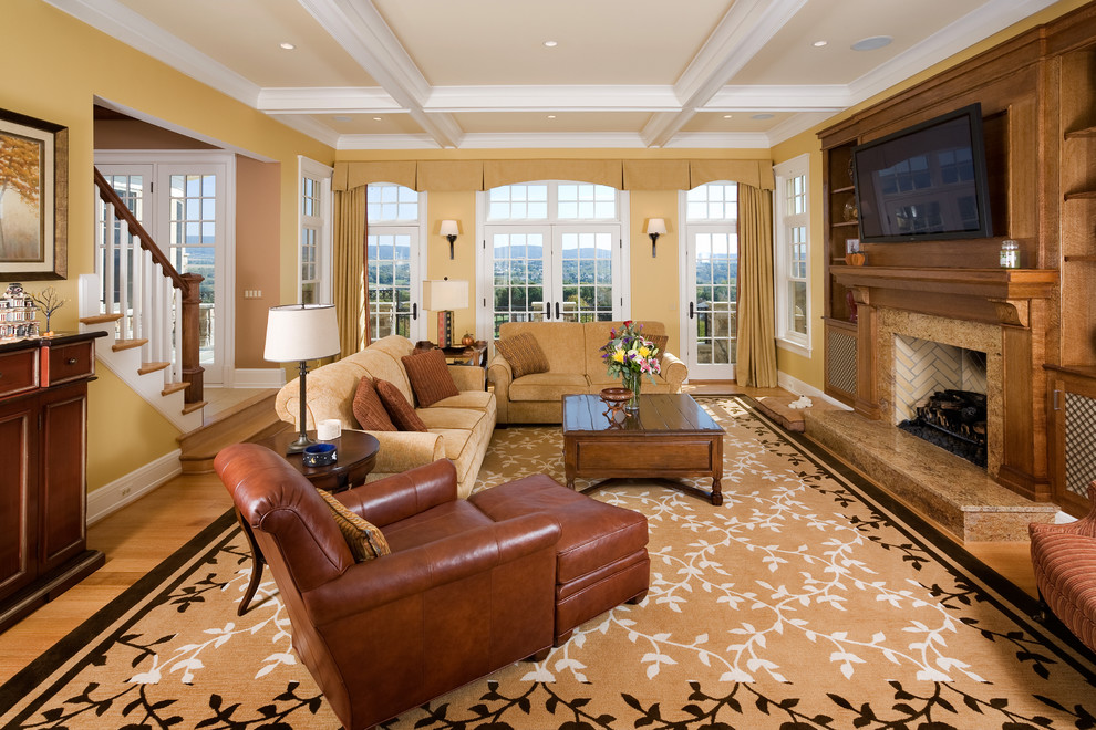 Esempio di un soggiorno classico aperto con pareti beige, parquet chiaro, camino classico, cornice del camino in legno e TV a parete
