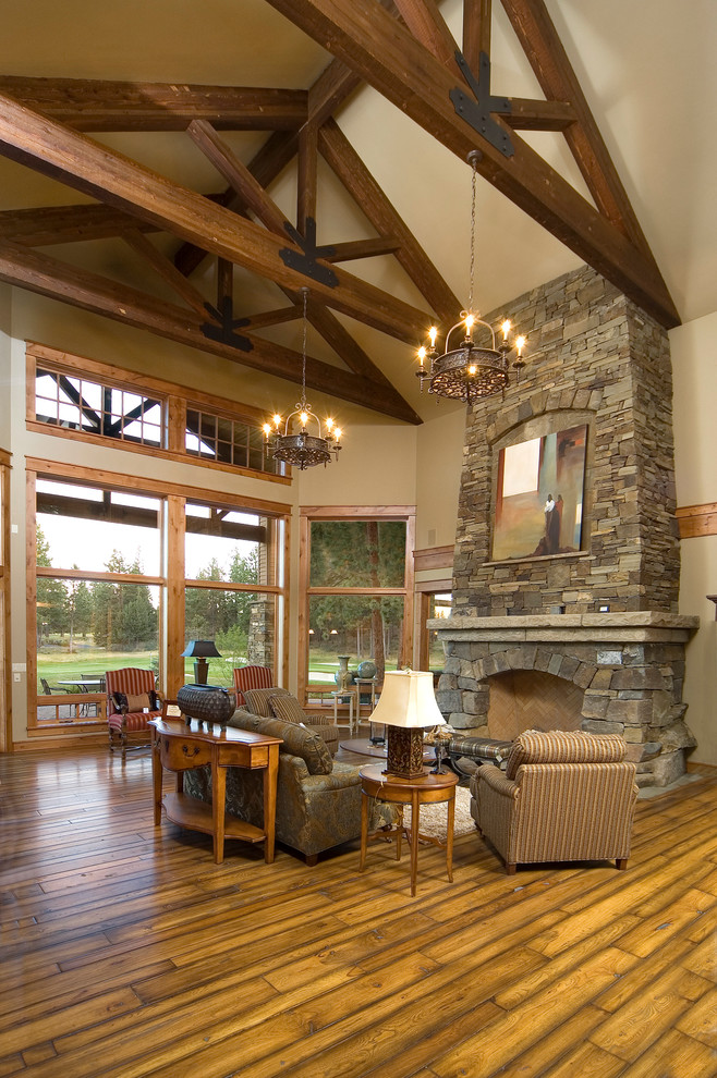 Rustic living room in Other with a stone fireplace surround.