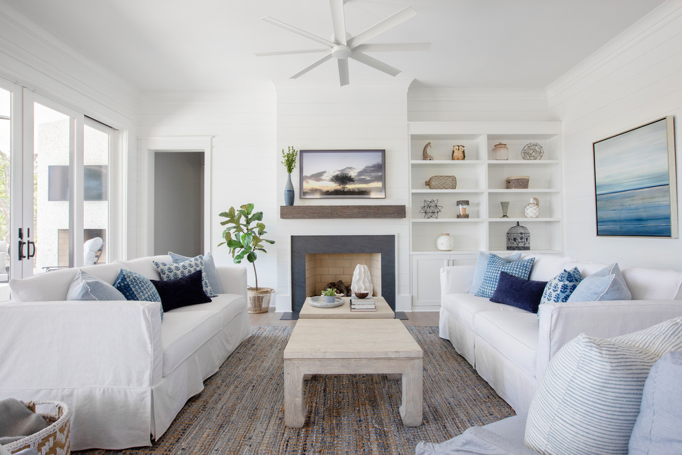 Maritimes Wohnzimmer mit weißer Wandfarbe und Kamin in Charleston