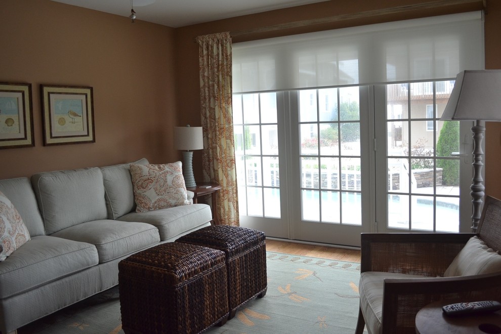 Foto di un soggiorno stile marino di medie dimensioni e chiuso con sala formale, pareti arancioni, pavimento in legno massello medio, nessun camino e nessuna TV