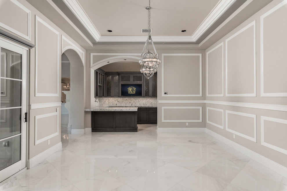 Стильный дизайн: огромная парадная, открытая гостиная комната в средиземноморском стиле с серыми стенами, мраморным полом, стандартным камином, фасадом камина из камня, телевизором на стене, серым полом и многоуровневым потолком - последний тренд