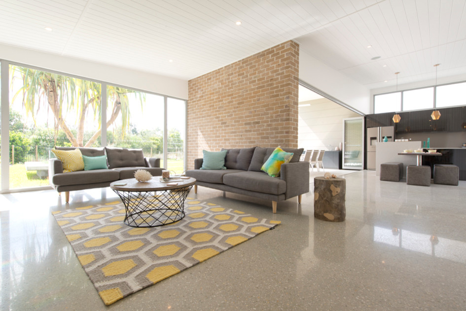 Foto di un soggiorno moderno aperto con pavimento in cemento