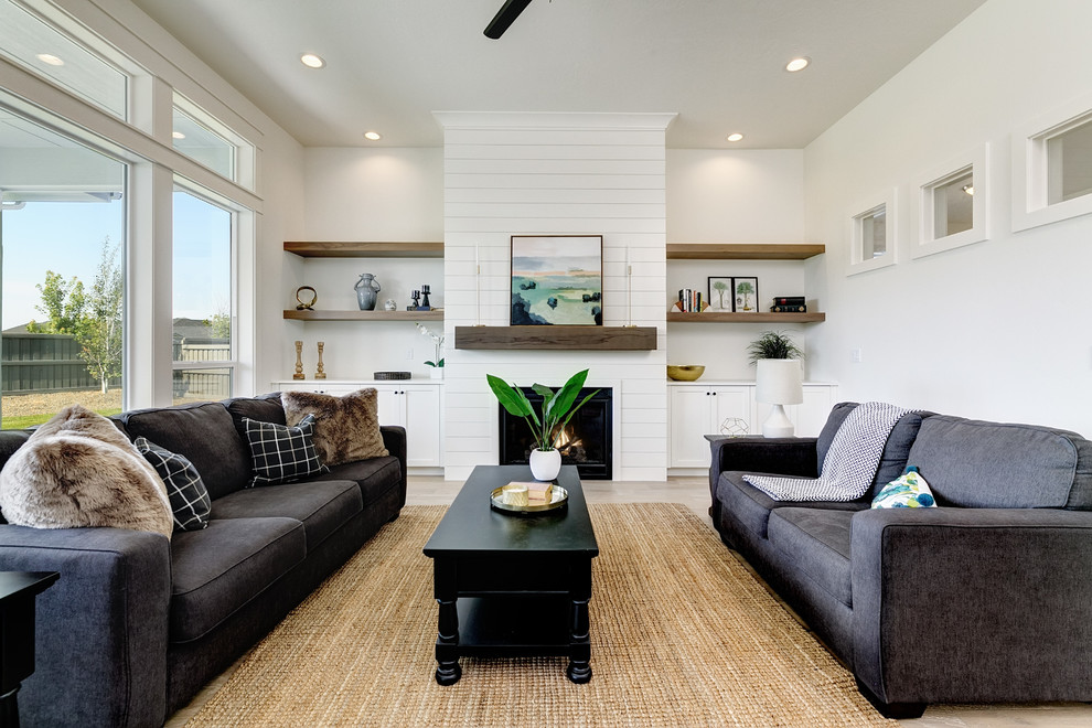 Repräsentatives, Fernseherloses Klassisches Wohnzimmer mit weißer Wandfarbe, hellem Holzboden und Kamin in Boise