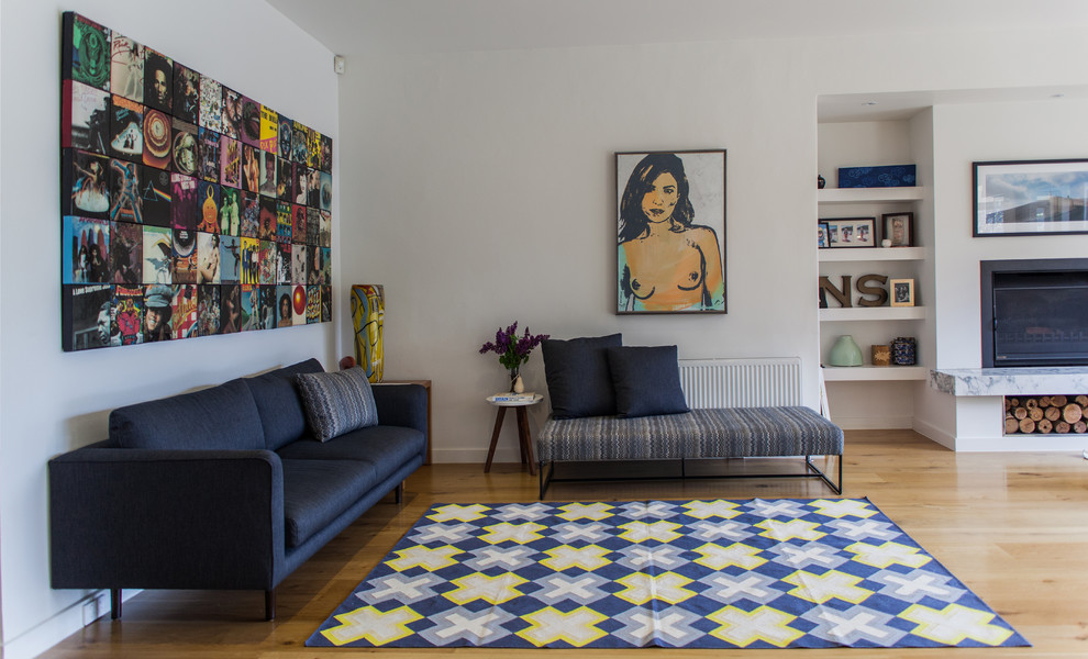 Immagine di un soggiorno minimal con pareti bianche, pavimento in legno massello medio e camino classico
