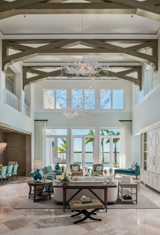 Inspiration pour un grand salon traditionnel ouvert avec un mur bleu, un sol en travertin, un téléviseur encastré, un sol beige, une salle de réception et éclairage.