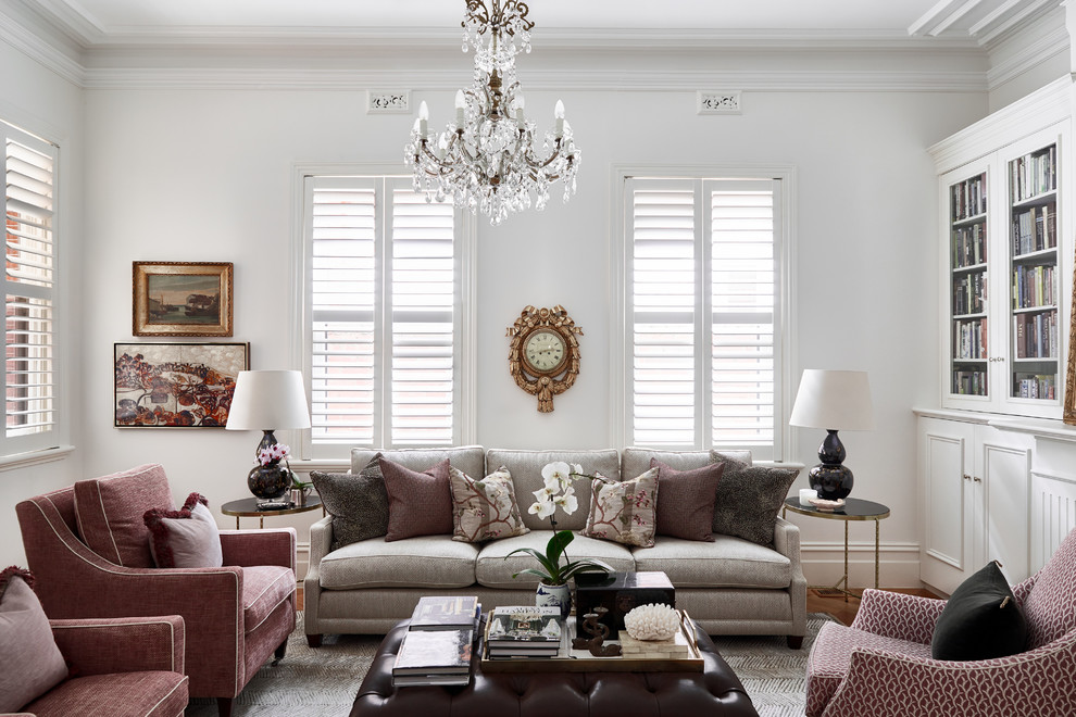 Immagine di un soggiorno classico di medie dimensioni con pareti bianche, pavimento in legno massello medio, sala formale e pavimento marrone
