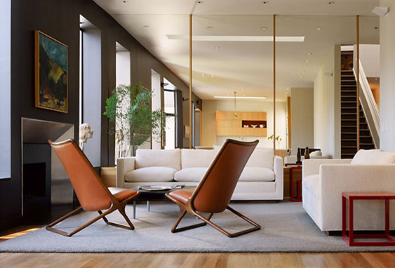 Immagine di un piccolo soggiorno minimalista aperto con pareti grigie, pavimento in legno massello medio e camino classico
