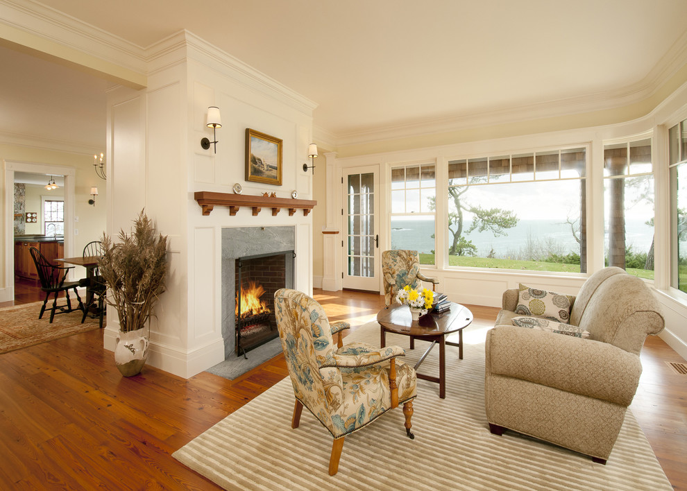 Foto de salón clásico con paredes beige, suelo de madera en tonos medios, todas las chimeneas y alfombra
