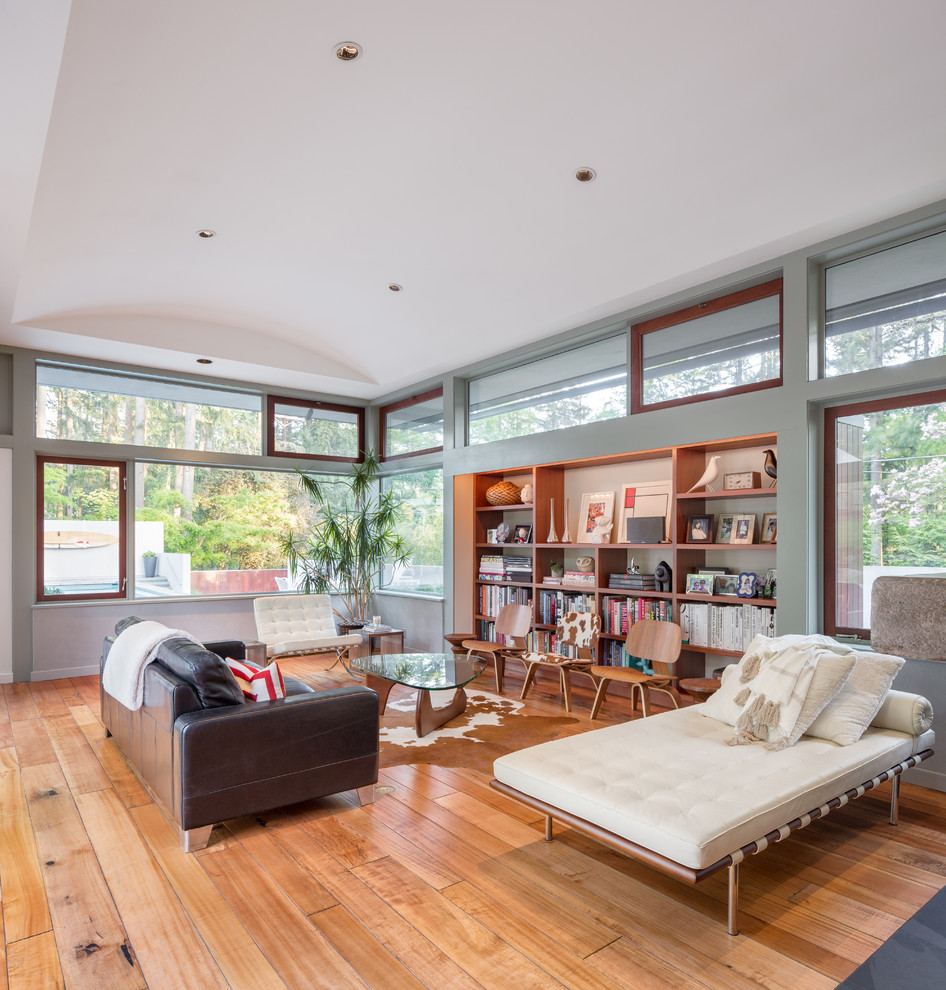 This is an example of a contemporary open plan living room in Portland with grey walls, medium hardwood flooring and brown floors.