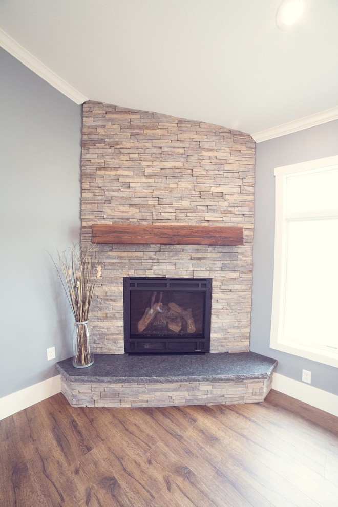 Living room - rustic open concept brown floor living room idea in Cedar Rapids with blue walls, a corner fireplace and a stone fireplace