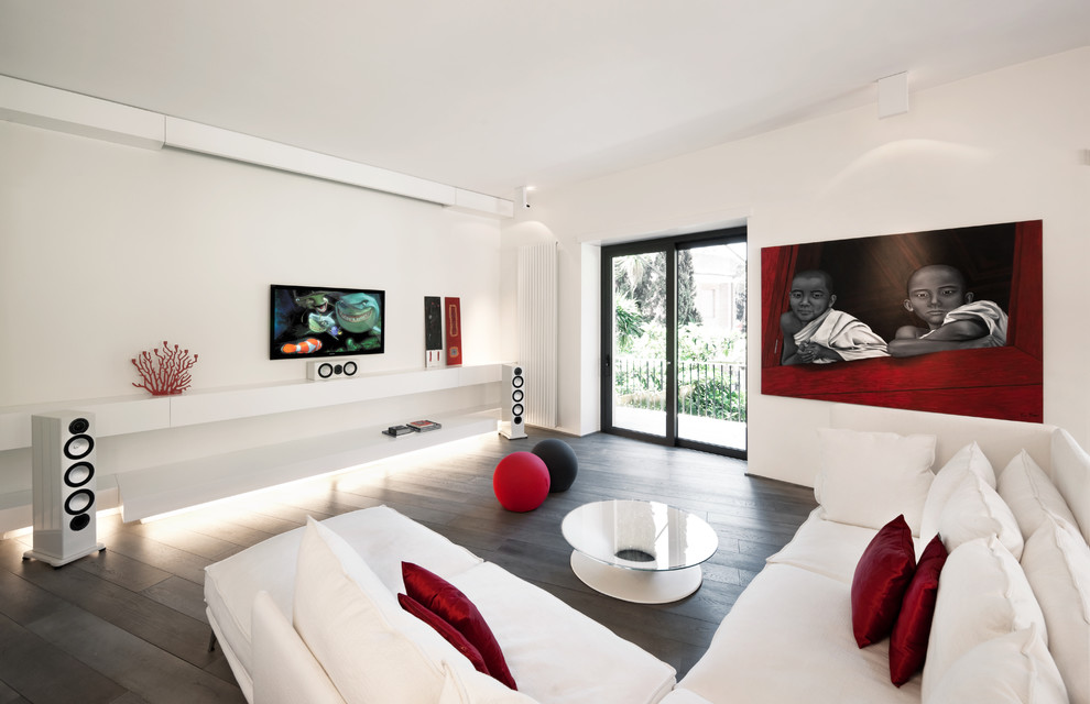 На фото: гостиная комната в современном стиле с белыми стенами, темным паркетным полом и телевизором на стене с