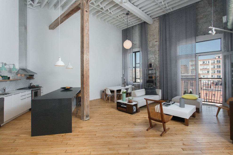 This is an example of a large urban open plan living room in Philadelphia with white walls, medium hardwood flooring, brown floors and no fireplace.