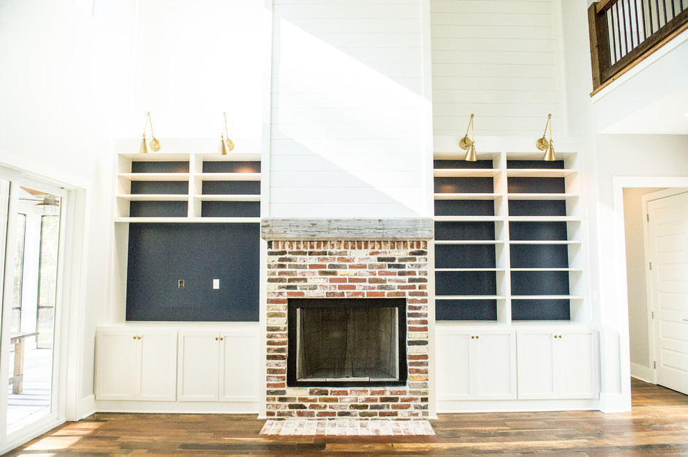 Living room - loft-style medium tone wood floor living room idea in Atlanta with a brick fireplace and a media wall