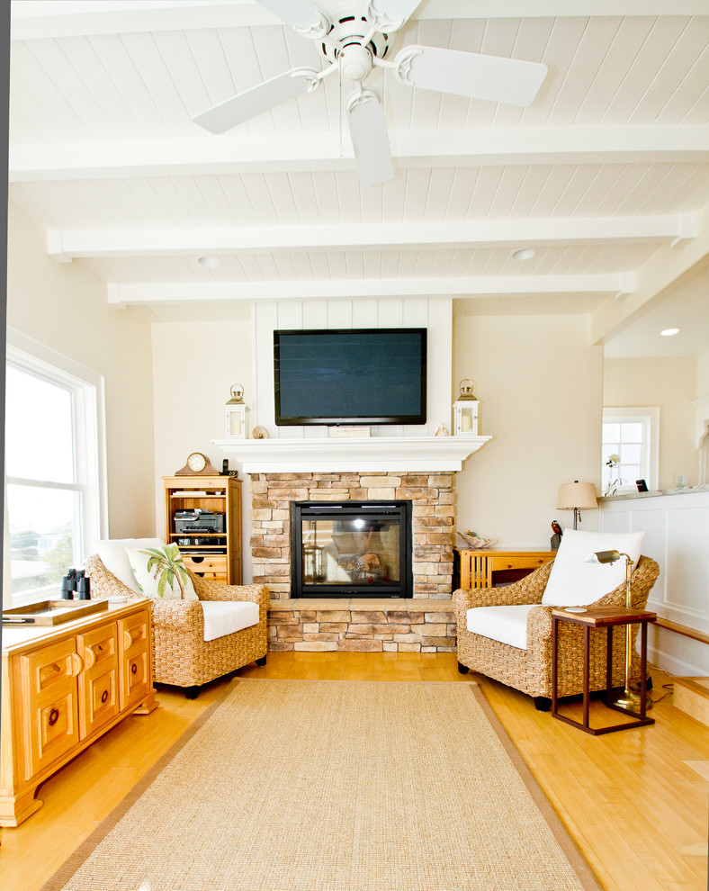 Foto di un soggiorno costiero di medie dimensioni e aperto con pareti bianche, parquet chiaro, cornice del camino in pietra e TV a parete