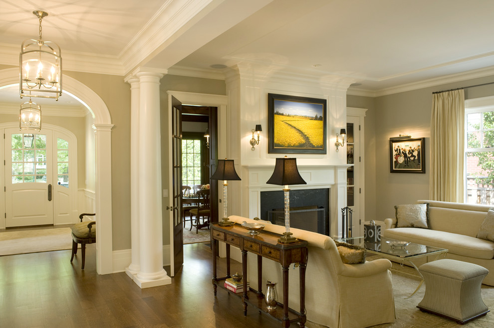 This is an example of a medium sized traditional formal enclosed living room in Chicago with beige walls, medium hardwood flooring, a standard fireplace, a wooden fireplace surround and no tv.