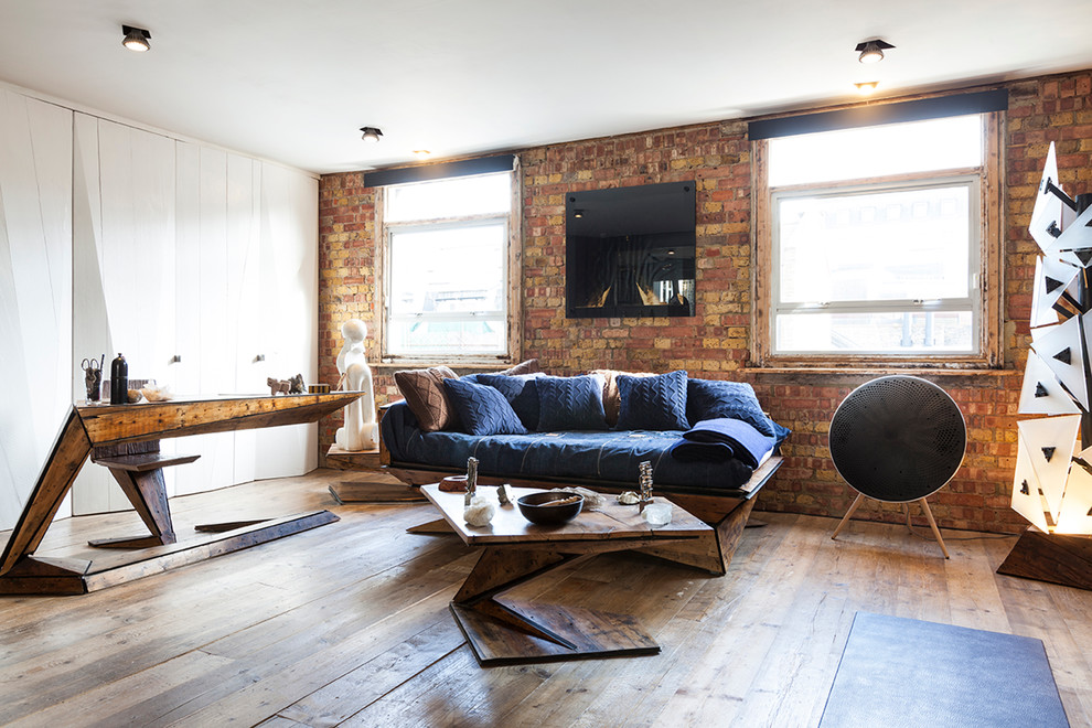 Photo of a small industrial living room in London with brown walls, medium hardwood flooring and brown floors.