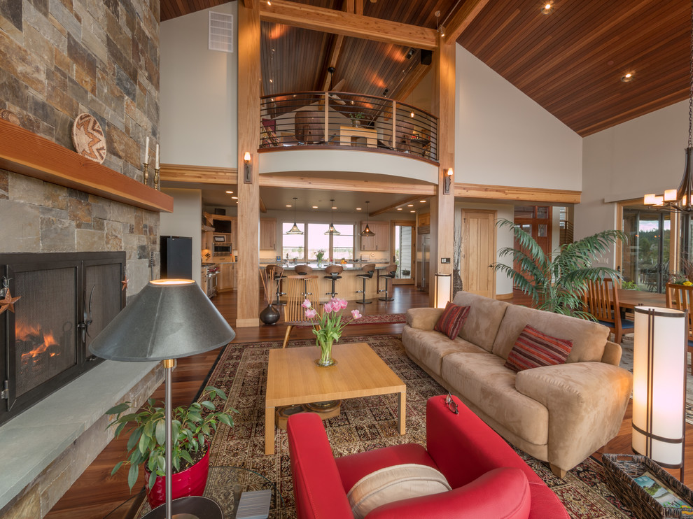 Example of a large eclectic medium tone wood floor living room design in Other with a stone fireplace