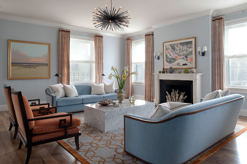 Пример оригинального дизайна: парадная гостиная комната в стиле неоклассика (современная классика) с синими стенами, темным паркетным полом, стандартным камином и красивыми шторами