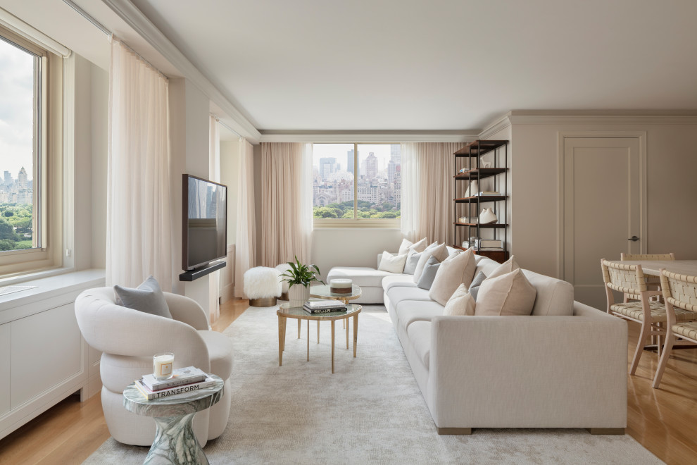 Trendy open concept light wood floor and beige floor living room photo in New York with gray walls and a wall-mounted tv