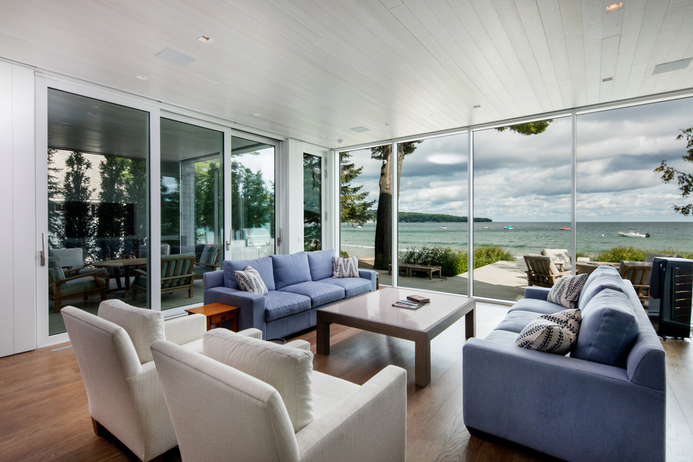 Ejemplo de salón para visitas costero de tamaño medio con paredes blancas y suelo de madera en tonos medios