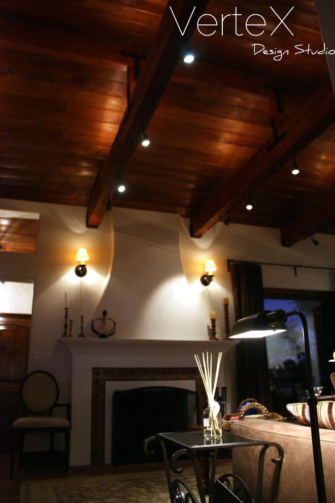 Mittelgroßes, Repräsentatives, Abgetrenntes Mediterranes Wohnzimmer mit weißer Wandfarbe, braunem Holzboden, Kamin, gefliester Kaminumrandung und Multimediawand in Los Angeles