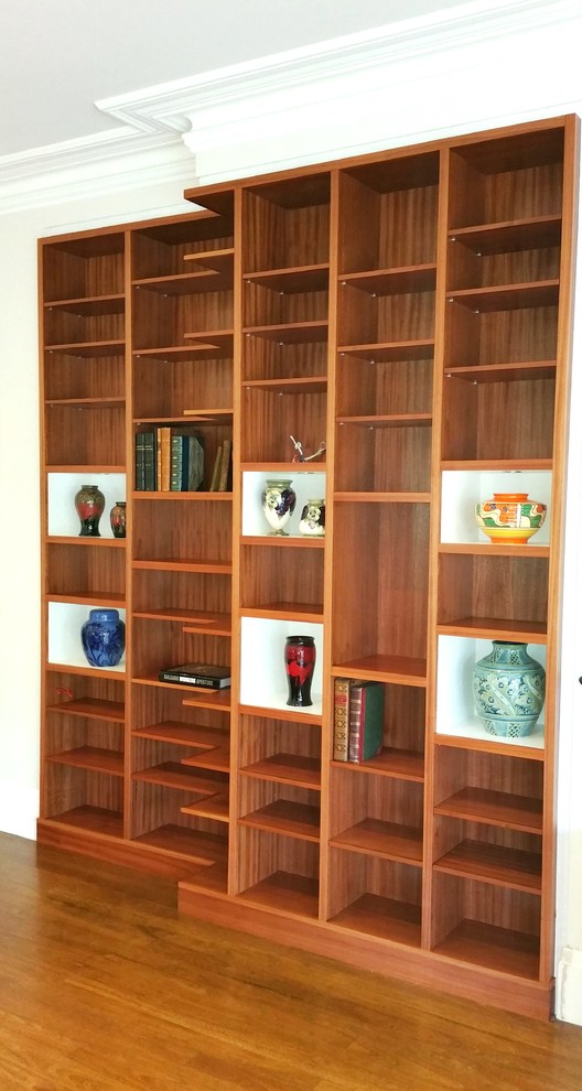 Ejemplo de biblioteca en casa cerrada vintage de tamaño medio con paredes blancas y suelo de madera clara