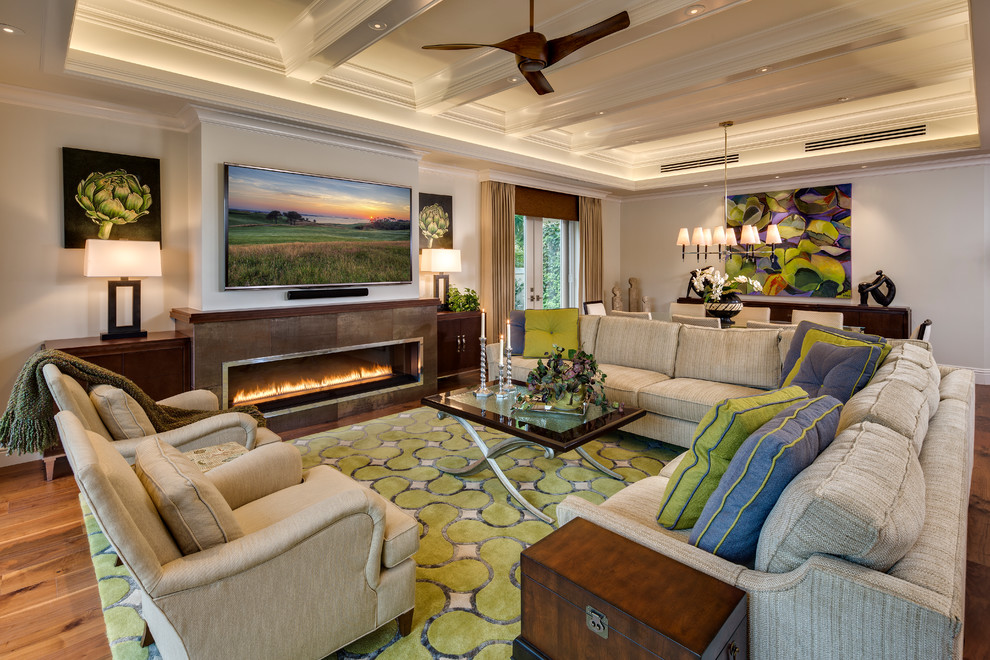 This is an example of a world-inspired formal open plan living room in Albuquerque with beige walls, medium hardwood flooring, a ribbon fireplace, a stone fireplace surround, a wall mounted tv and brown floors.