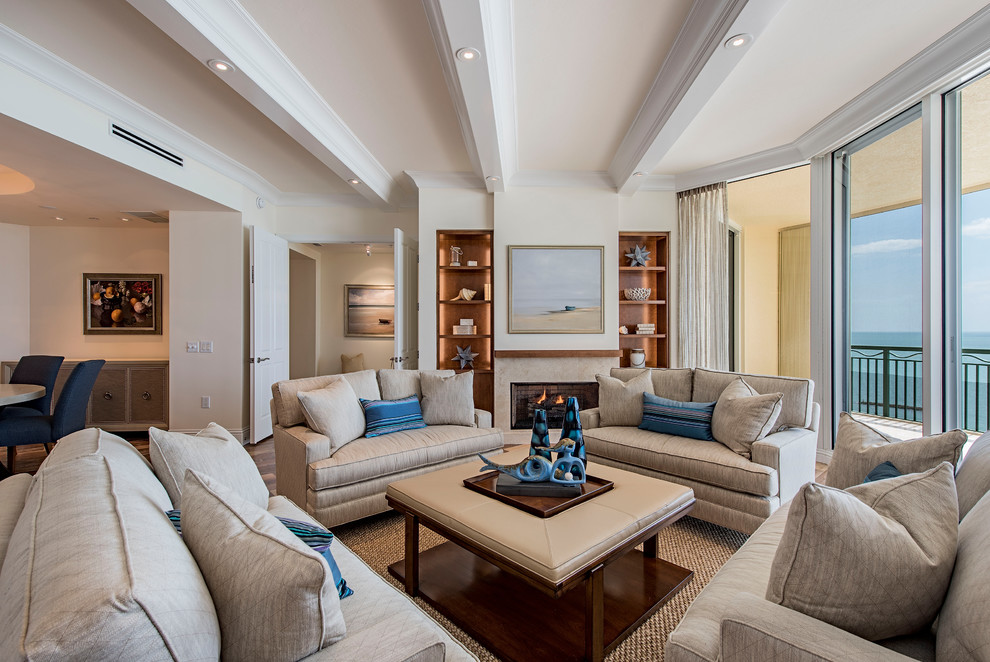 Стильный дизайн: открытая гостиная комната в морском стиле с белыми стенами, паркетным полом среднего тона, стандартным камином, фасадом камина из камня и коричневым полом - последний тренд