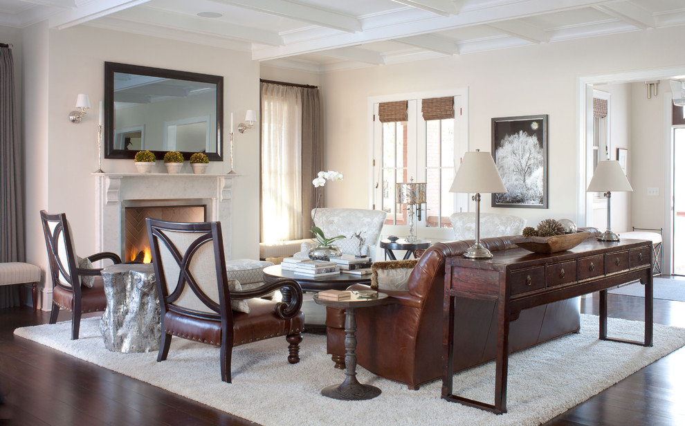 На фото: гостиная комната в классическом стиле с бежевыми стенами, стандартным камином и красивыми шторами с