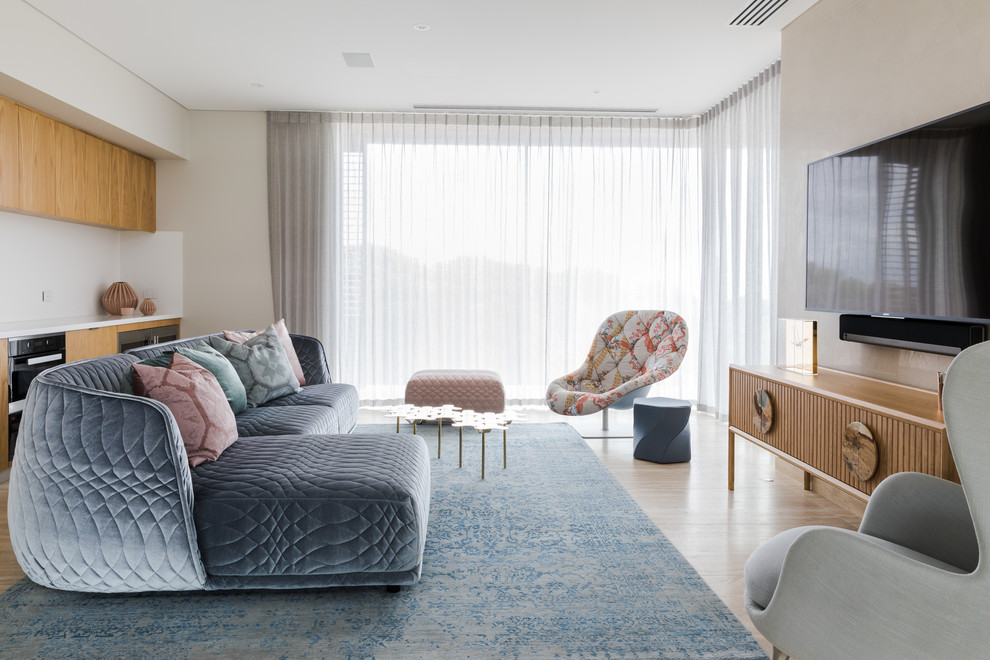 Ispirazione per un soggiorno design di medie dimensioni e aperto con pareti beige, parquet chiaro, TV a parete e pavimento marrone