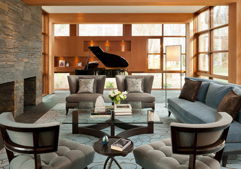 На фото: гостиная комната в современном стиле с музыкальной комнатой, полом из сланца, стандартным камином, фасадом камина из камня и синим диваном с