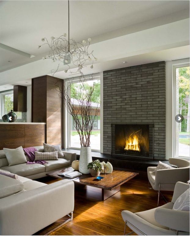 Inspiration for a large modern formal open plan living room in Burlington with a standard fireplace, a brick fireplace surround, a wall mounted tv, multi-coloured walls and laminate floors.