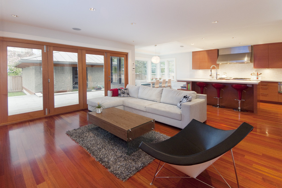 Modern open plan living room in Vancouver with white walls and red floors.