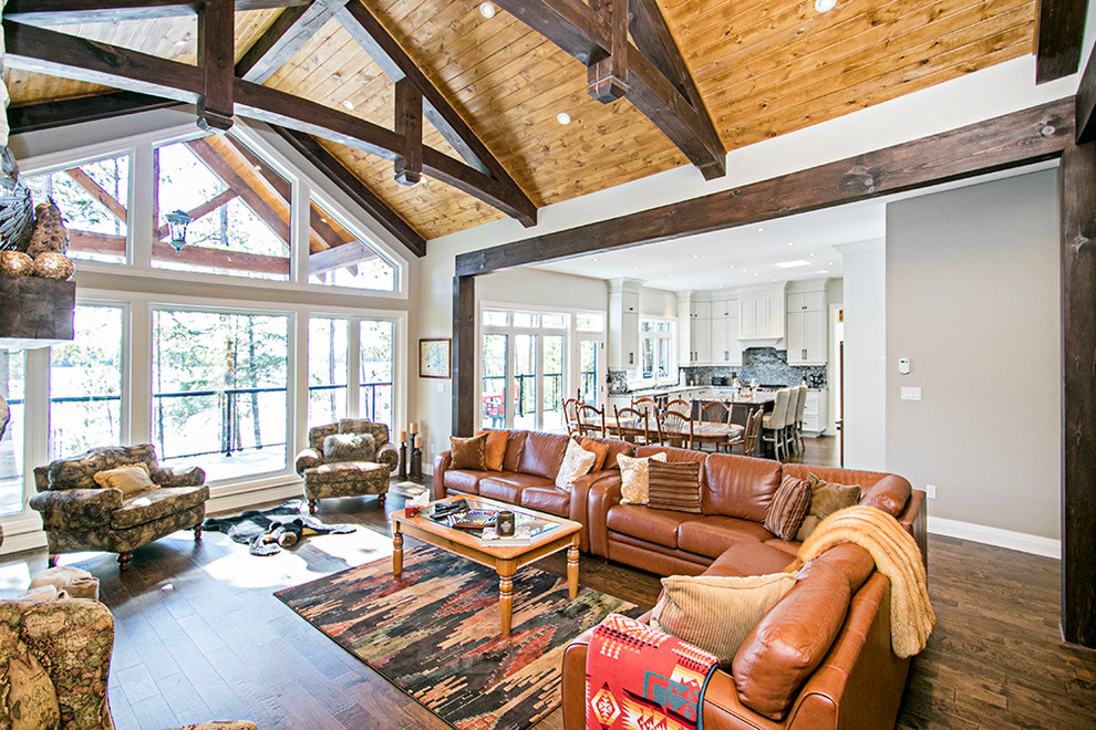 Imagen de salón para visitas abierto de estilo de casa de campo con paredes blancas, suelo de madera clara, todas las chimeneas, marco de chimenea de piedra y suelo marrón
