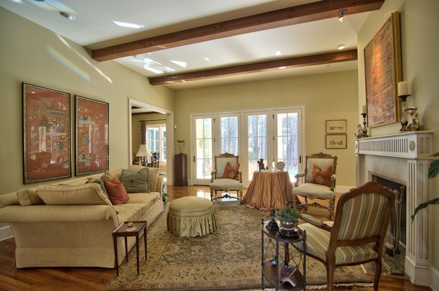 Großes, Fernseherloses, Abgetrenntes Uriges Wohnzimmer mit grüner Wandfarbe, braunem Holzboden, Kamin und Kaminumrandung aus Stein in Raleigh