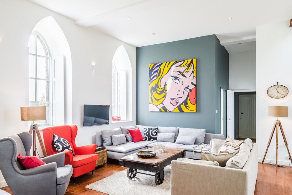 Свежая идея для дизайна: гостиная комната в стиле неоклассика (современная классика) с серыми стенами, паркетным полом среднего тона и телевизором на стене - отличное фото интерьера