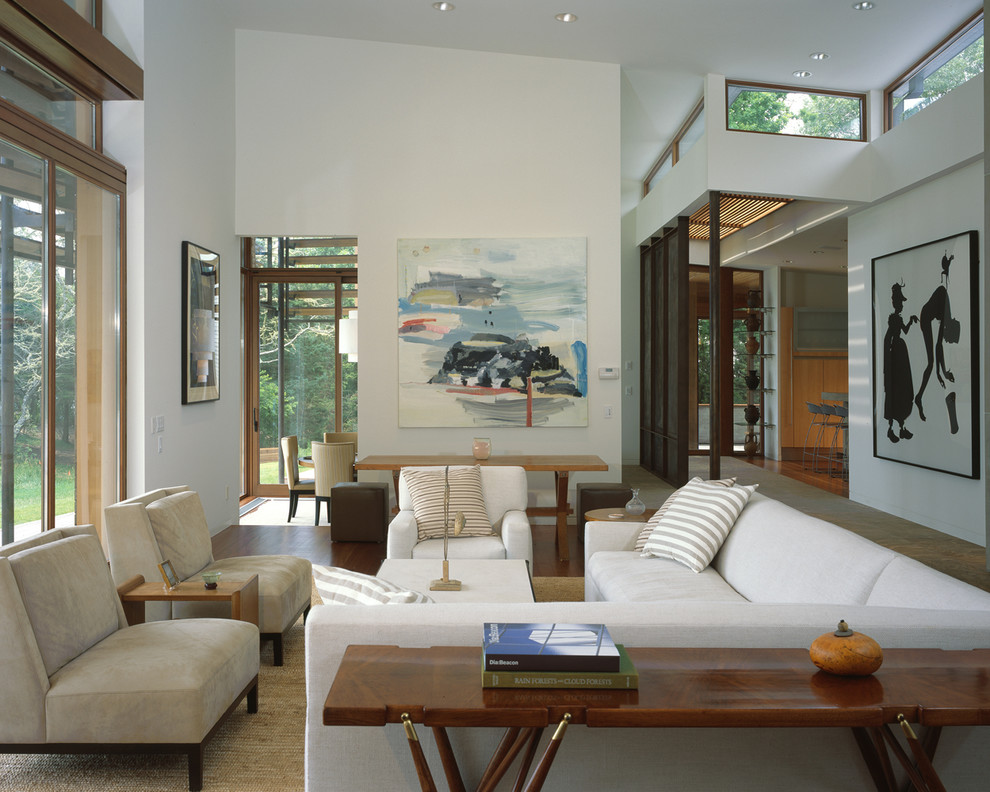 Стильный дизайн: огромная открытая гостиная комната в современном стиле с белыми стенами и паркетным полом среднего тона без телевизора - последний тренд
