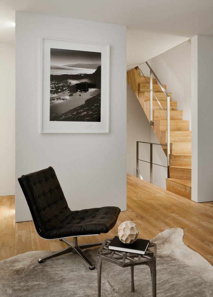 Источник вдохновения для домашнего уюта: двухуровневая гостиная комната в стиле модернизм с белыми стенами, светлым паркетным полом, стандартным камином и фасадом камина из кирпича