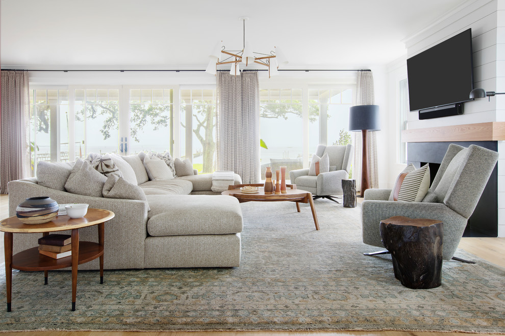Offenes Klassisches Wohnzimmer mit weißer Wandfarbe, hellem Holzboden, TV-Wand, Kamin und beigem Boden in Charleston