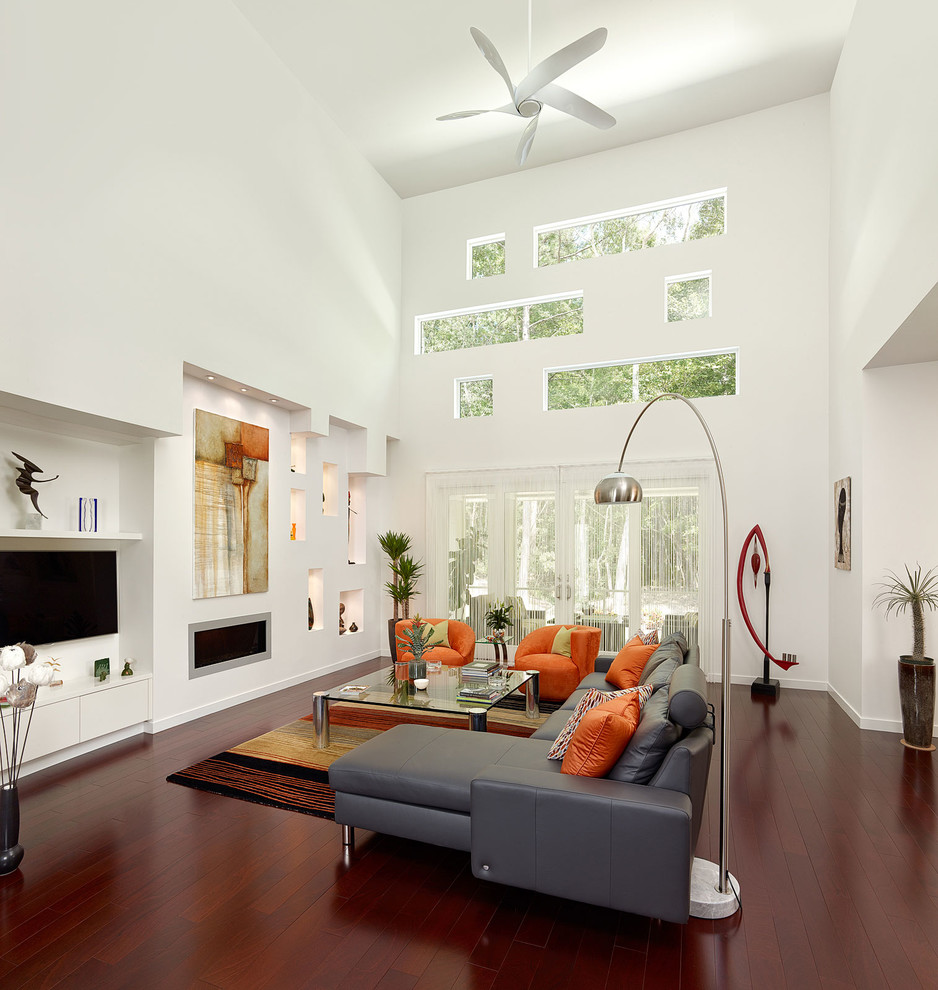 Großes, Offenes, Repräsentatives Modernes Wohnzimmer mit weißer Wandfarbe, dunklem Holzboden, Gaskamin, Kaminumrandung aus Metall, TV-Wand und braunem Boden in Charleston