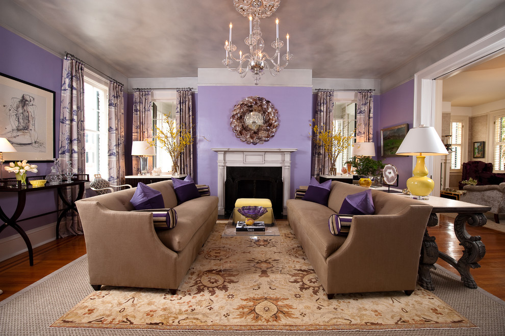 Cette photo montre un salon chic ouvert avec une salle de réception, un mur violet, un sol en bois brun, une cheminée standard et un manteau de cheminée en plâtre.