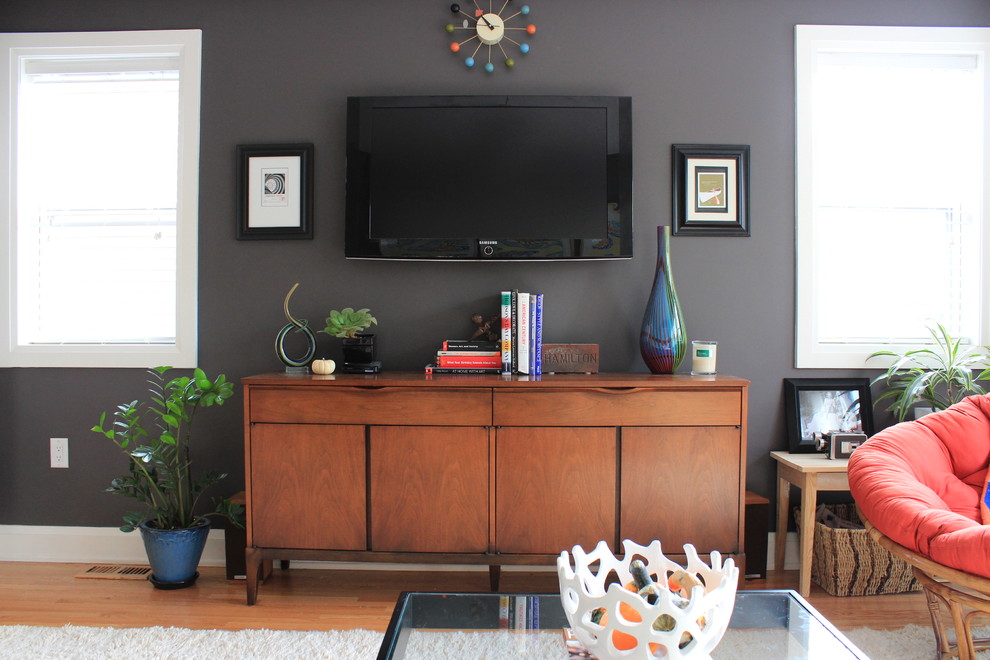 Immagine di un soggiorno bohémian di medie dimensioni e chiuso con pareti grigie, parquet chiaro e TV a parete