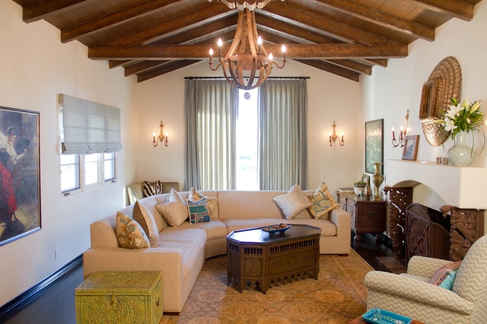 На фото: гостиная комната в средиземноморском стиле с стандартным камином и красивыми шторами с